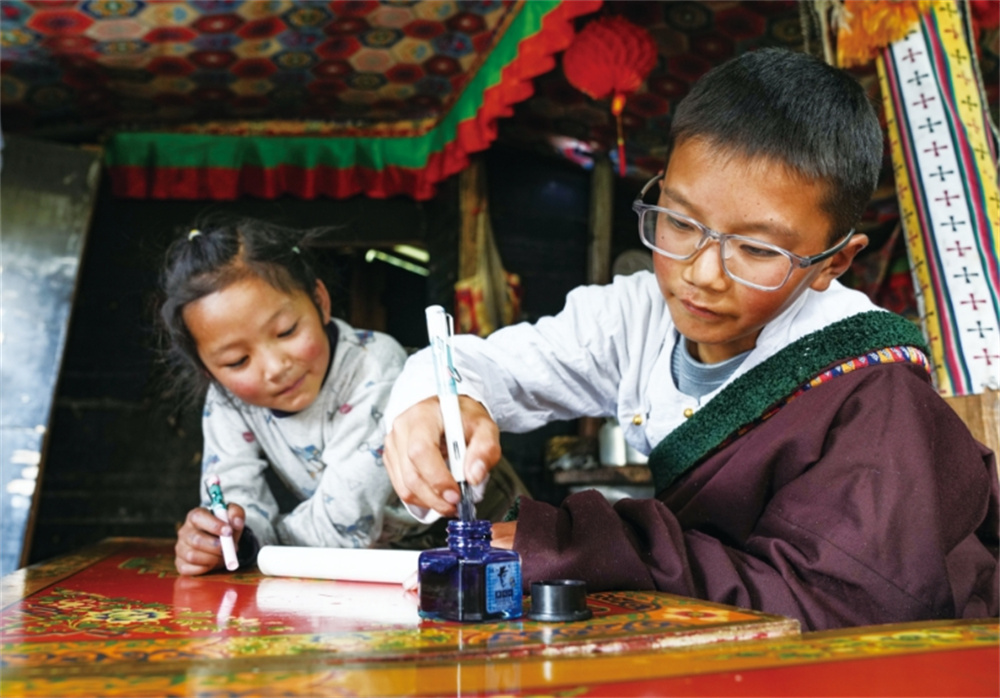 贡乔热旦（左）教表妹学习藏文书法。晋美多?? ??.jpg